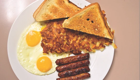 Two eggs with sausage links, hash browns and toast